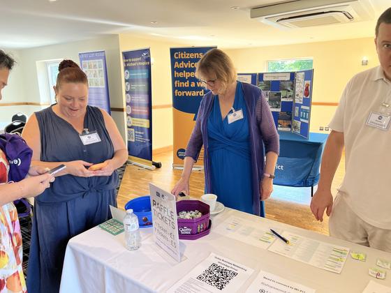 Members chatting around an exhibitor's display table