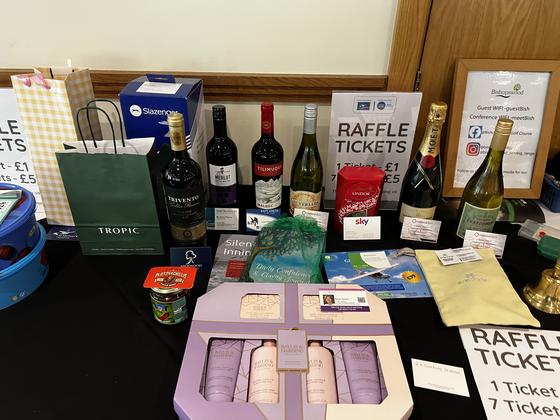 The charity raffle prize table with wine, hampers and ticket signs