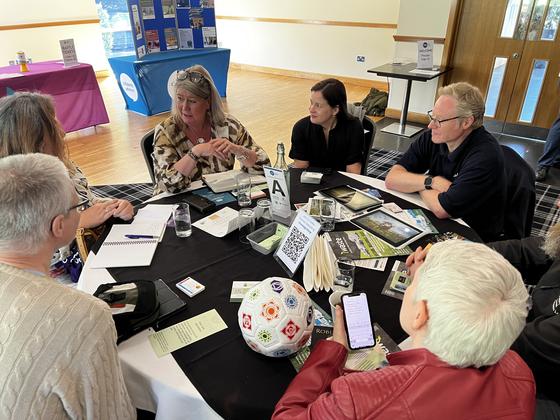 Members at a table near the display stands