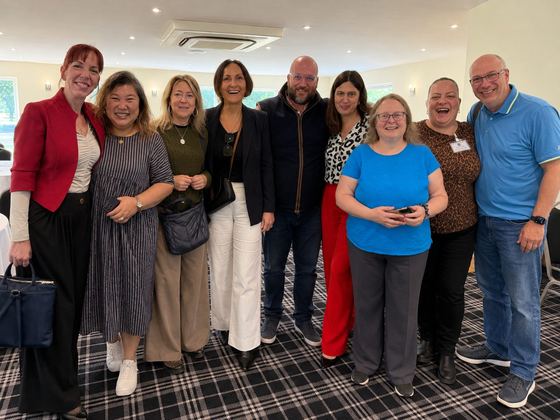 A big group of members gathered together for a photo in the meeting room