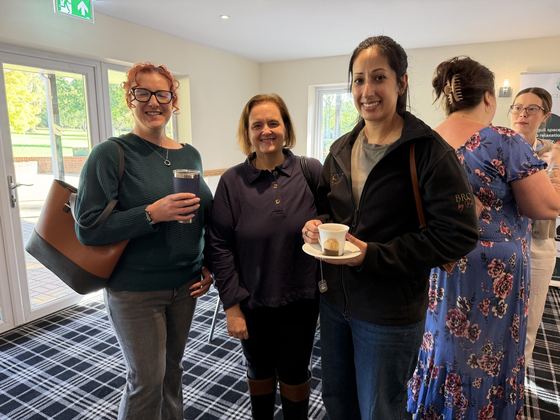 Three members with their coffees near the terrace doors