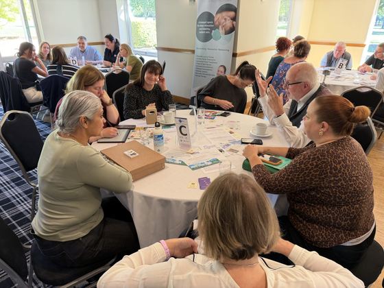 A busy Table C with members chatting over coffee