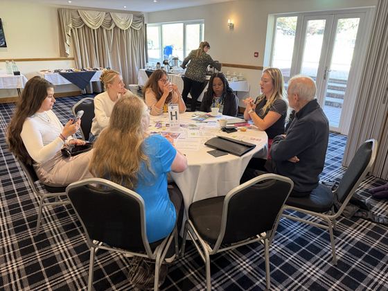 Members at Table H mid conversation