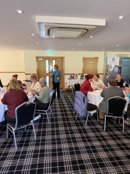 An organiser speaking to the room from between the tables