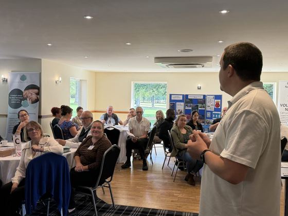 An organiser speaking to a full room
